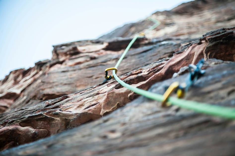 Climber wearing premium leather gloves on rocky ascent