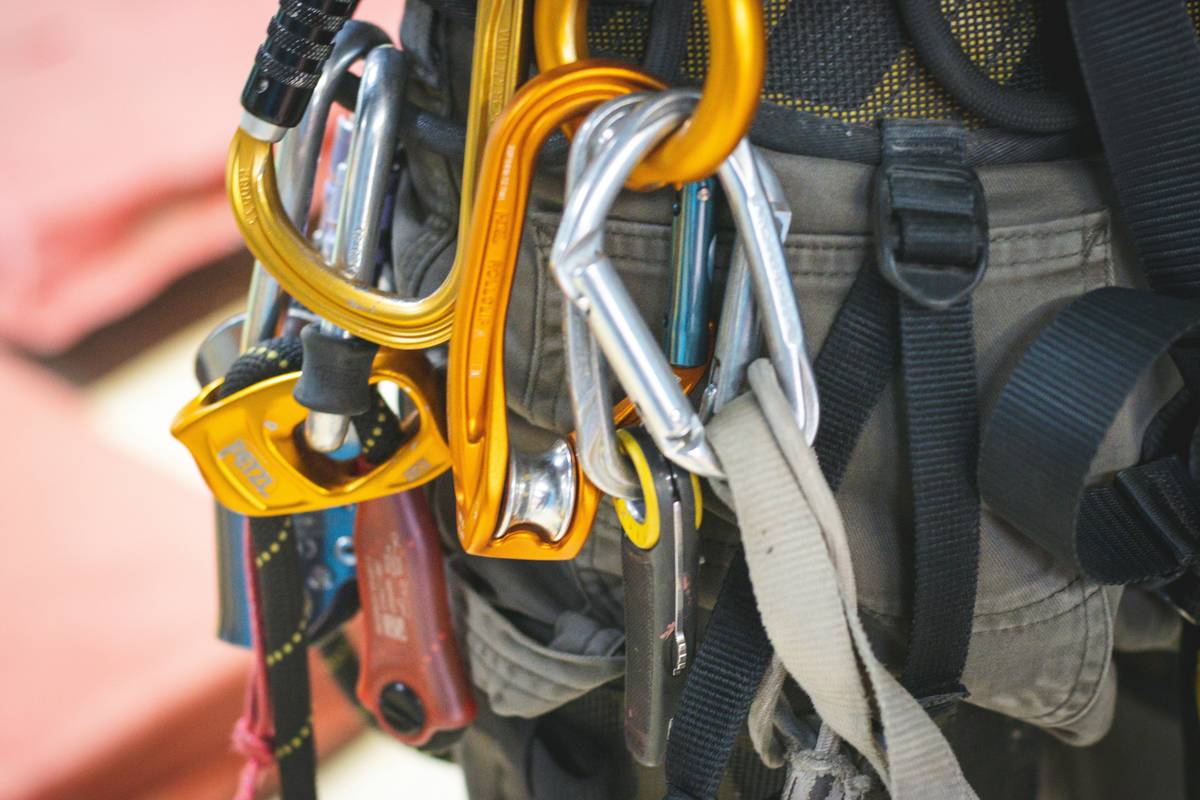 Climber reviewing Safety Gear Checklists with climbing gloves laid out on rock surface