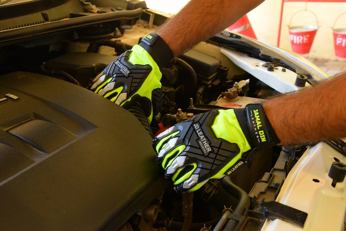 Close-up of climbing gloves showing Safety Standards Compliance certification labels and reinforced stitching