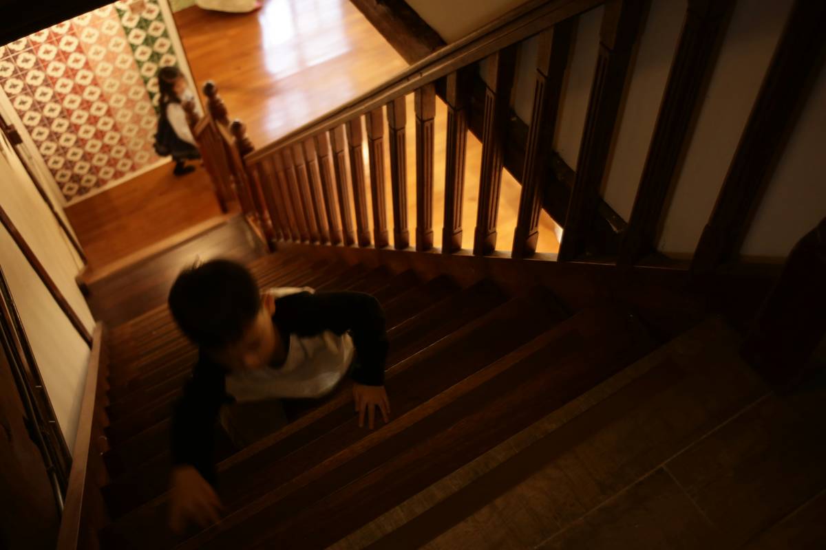 safe climbing for toddlers: toddler wearing small climbing gloves on an indoor wall with parent spotting below